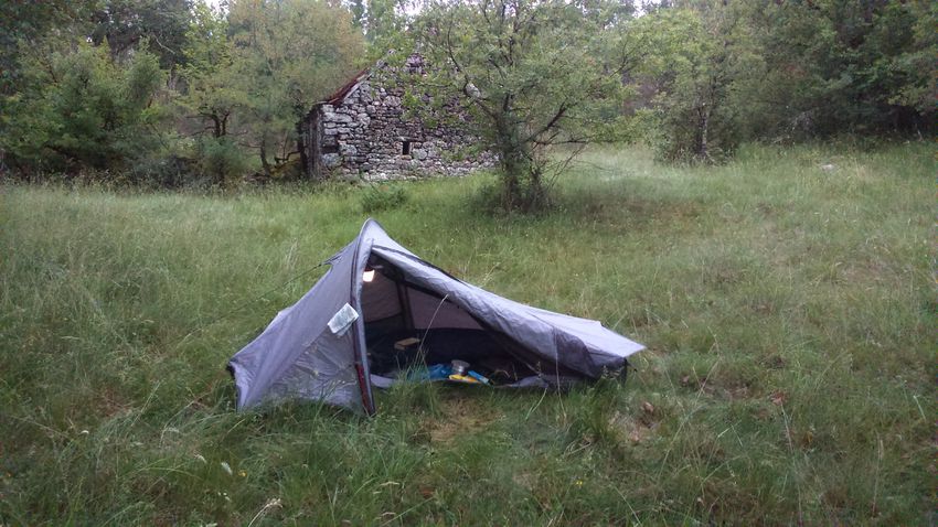la tente installée à proximité d'une cabane en pierre sèche